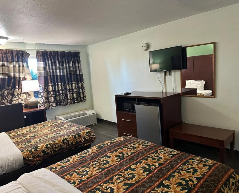 Guest room with bed, television, and desk